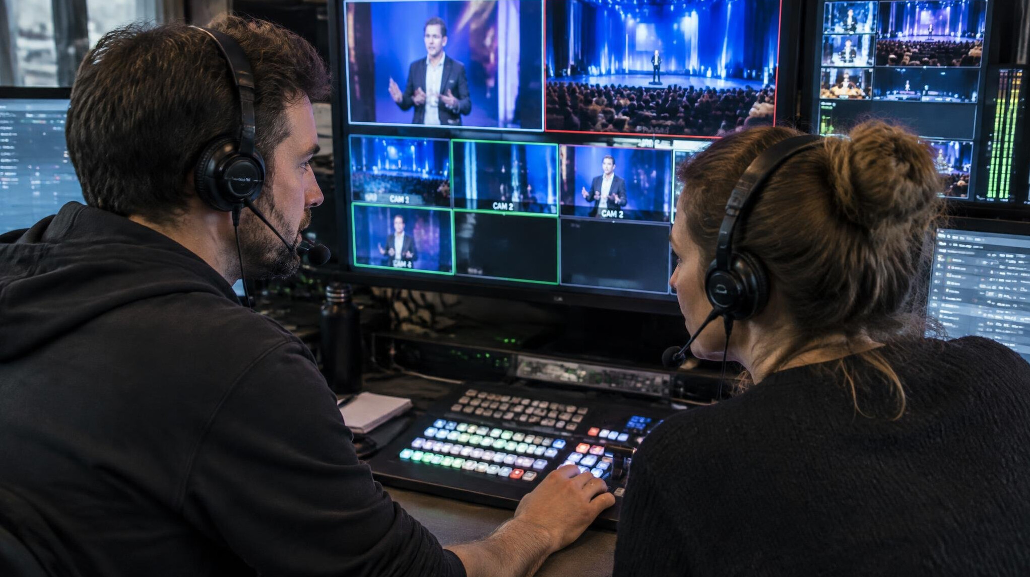 Two people monitoring a live video switcher during a broadcast